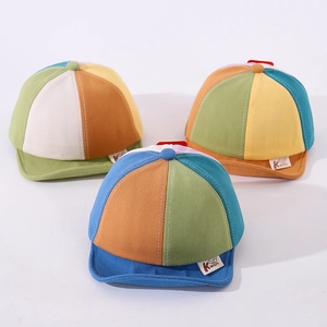 Close-up of color-block baby baseball caps with soft brim and cartoon letter K patch