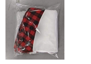 Detail view of red and black plaid Christmas tree skirt fabric in a clear plastic bag