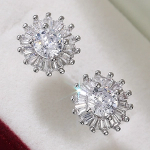 Macro shot of silver sunflower earrings featuring central round and baguette cut zircons