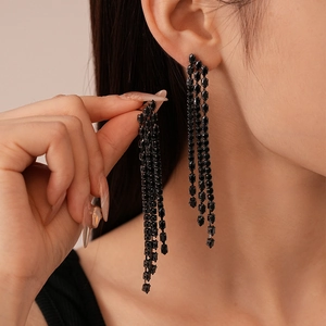 Gros plan de boucles d'oreilles pendantes noires avec strass portées par un mannequin