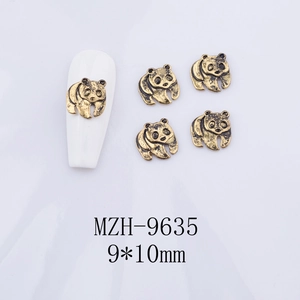 Macro detail of golden panda alloy nail art charms with black accents on white tips