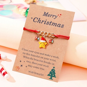 Christmas wish bracelet with red woven cord and gold star pendant on kraft card