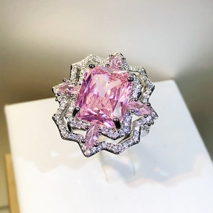 Macro shot of rectangular pink gemstone ring with star-shaped diamond frame detail