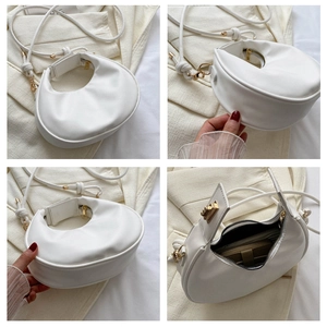 Detail view of the white crescent PU leather handbag with smooth zipper and metal buckle