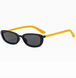 Detail view of oval cat-eye sunglasses featuring bold black frames and vibrant yellow temples