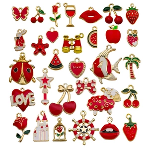 Mix of 26 red enamel and gold alloy charms featuring fruit, animals, and hearts