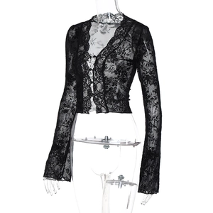 Detailed view of the sheer floral lace pattern and ribbon tie closure on the black cardigan