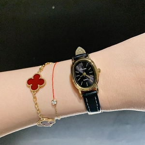 Elegant women's quartz watch with black oval dial and leather strap for a vintage look