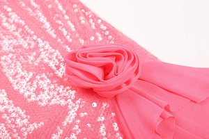 Detail of pink sequined fabric featuring a delicate handmade mesh rose ornament on a dress