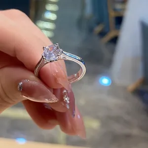 Detailed close-up of a classic four-prong solitaire round diamond ring on finger