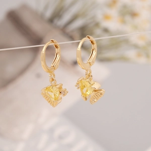 Close-up of golden heart-shaped zircon earrings with elegant fan-textured detailing