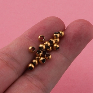 Close-up of small hollow golden stainless steel beads for DIY jewelry making