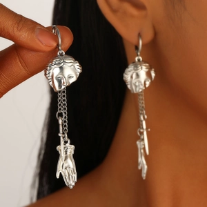 Gothic silver punk earrings with vintage portrait and hand charm pendant on model
