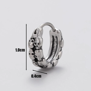 Detailed view of silver skull huggie earrings with dimensions 1.0cm by 0.4cm