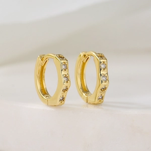 Minimalist gold plated hexagonal hoop earrings with cubic zirconia on marble background