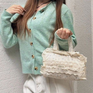 Vue détaillée de la bordure en dentelle et des motifs floraux sur un sac en toile