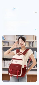Détail du sac à dos rouge et blanc avec slogan imprimé et multiples poches zippées