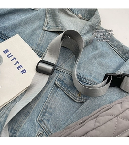 Detail of adjustable gray nylon strap and buckle on quilted crossbody chest bag