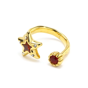 Macro shot of gold adjustable ring with star-shaped red zircon and textured metal band