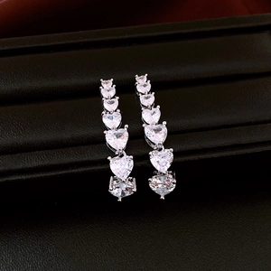 Macro shot of silver-plated heart-shaped crystal drop earrings with gradient tassels