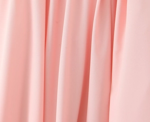 Detailopname van zachtroze chiffon stof met fijne textuur en soepel vallende plooien