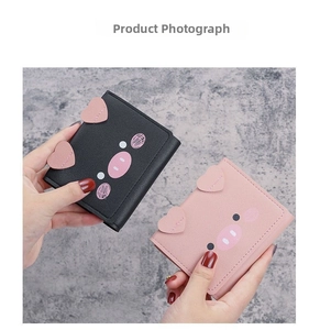 Close-up of cute cartoon pig mini wallets in pink and black PU leather with heart ears