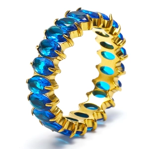 Close-up of eternity ring with blue oval-cut zircon and gold-plated stainless steel band