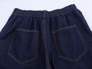 Detailansicht der dunkelblauen Jeans mit Gummizug und gelb genähten Gesäßtaschen