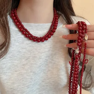Detail of elegant double-layered deep red glass bead necklace on a model's neck