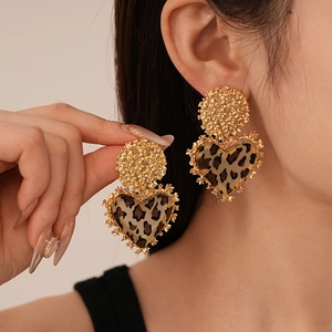 Close-up of vintage heart earrings with leopard print resin and golden metal texture