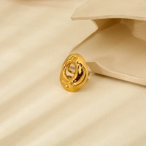Detailed close-up of a 18K gold-plated stainless steel geometric ring on textured fabric