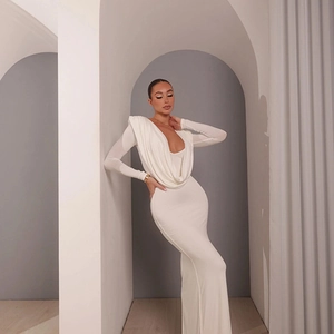 Gros plan sur l'élégant décolleté drapé et les épaulettes d'une robe longue blanche
