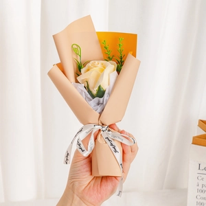 Detail of single pale yellow soap rose bouquet with Just for You ribbon in soft hand held view