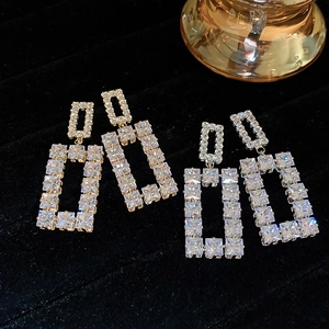 Macro detail of geometric cubic zirconia drop earrings in gold and silver finish