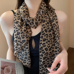 Detail of a lightweight chiffon leopard print scarf styled on a black summer top