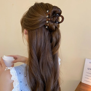 Brown resin hair claw clip with bear detail shown on a woman for hair styling