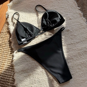 Close-up of black sequined bikini set with adjustable straps and size S label