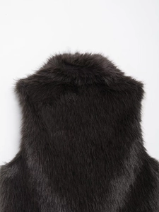 Detailed macro texture of dark brown faux fur vest with long plush fibers on the back