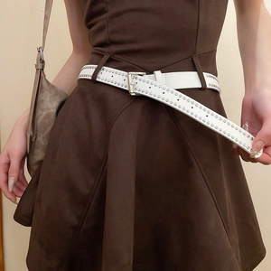 Detail of white leather punk belt with silver metal rivets on dark brown dress waist