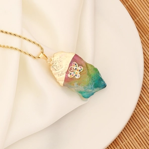 Macro detail of rainbow crystal stone necklace with gold butterfly and zircon inlay