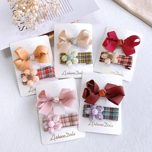 Close-up of girls ribbon bow hair clips and floral fabric clips set in 5 colors