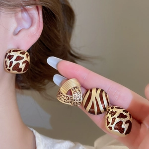 Detailed close-up of vintage animal print stud earrings with leopard and zebra patterns