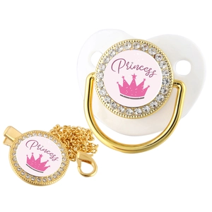 Detail of baby pacifier set with golden crown and crystal Princess design on white base