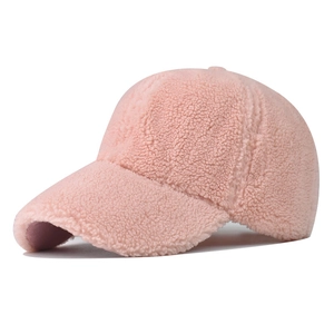 Dettaglio della texture in lana di agnello rosa sul berretto da baseball invernale
