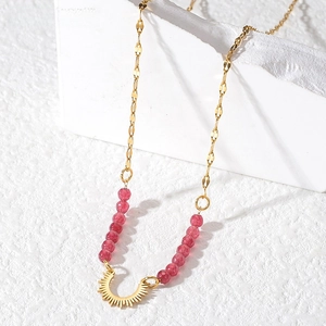 Detail of bohemian gold beaded necklace with pink stones and sunbeam pendant