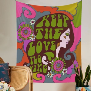 Detail view of colorful psychedelic tapestry with Keep The Love Flowing text on wall