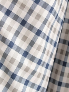 Detailed macro view of the blue and grey plaid fabric with fine diagonal twill weave texture