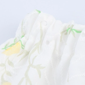 Set bianco maglia senza maniche e gonna con ricami floreali gialli e dettagli traforati