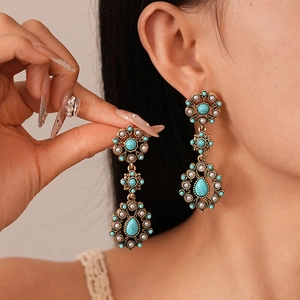 Vintage bohemian flower drop earrings with turquoise stones and white pearls on model