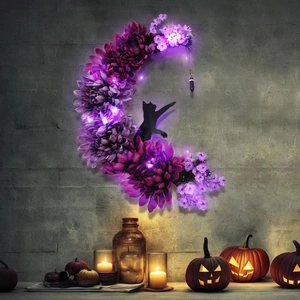 Detail of moon wreath with black cat silhouette, purple flowers, and warm LED lights